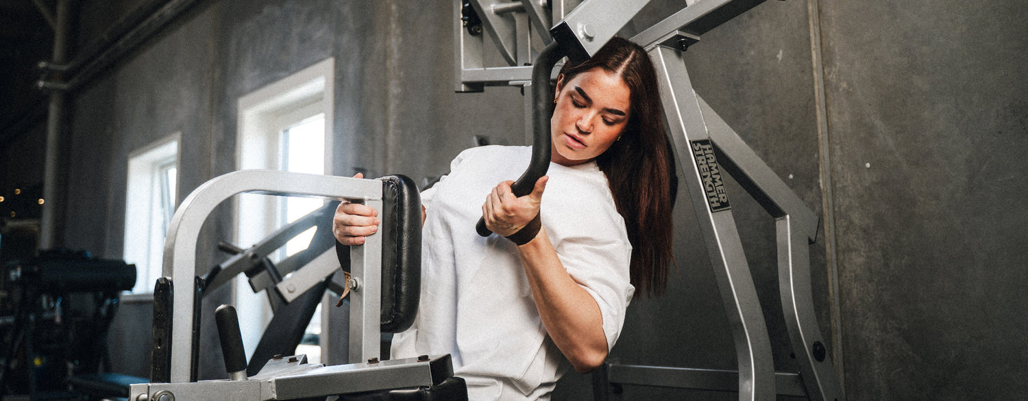 Kvinde træner med StrapIt lifting straps i fitnesscenter