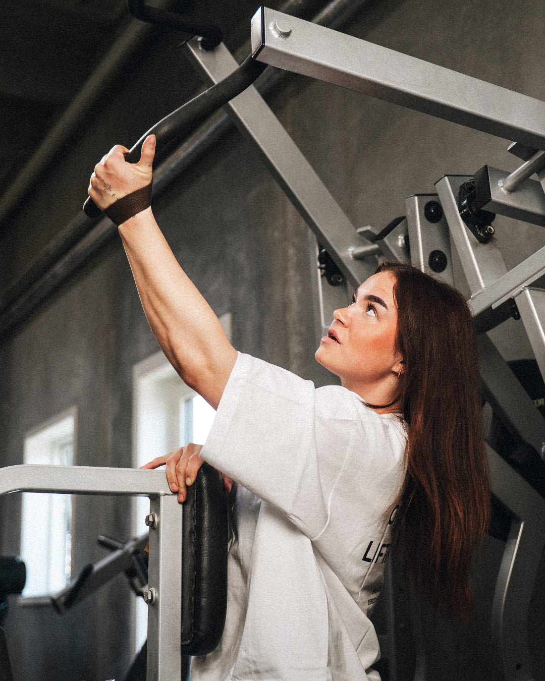 Kvinde træner med StrapIt lifting straps i fitnesscenter